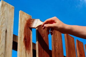 Hand staining wooden fence