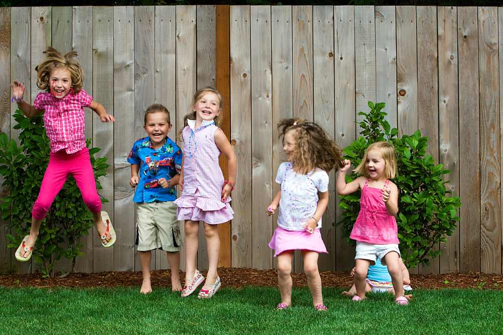 Image of yard enclosed by a security fence with children playing