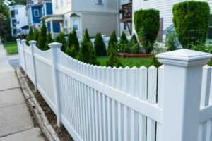 A white picket fence surrounding a residential home near Nicholasville, KY, during the day